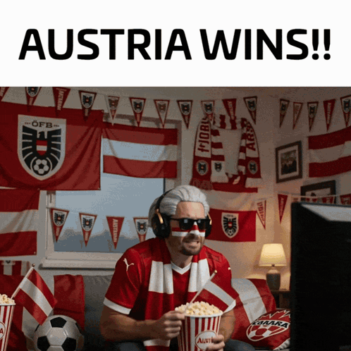 A Man Sitting On A Couch Holding A Popcorn Bucket That Says Austria Wins GIF