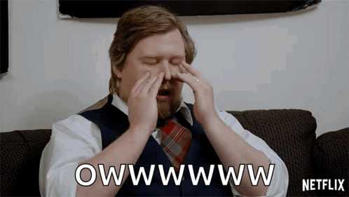 A Man Sitting On A Couch With His Eyes Closed And A Netflix Logo In The Background GIF