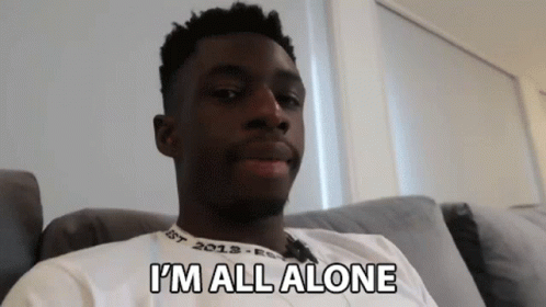 A Man Sitting On A Couch With The Words I 'M All Alone Written On His Shirt GIF