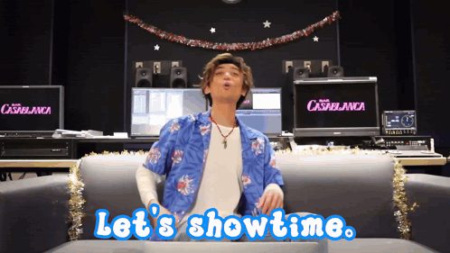 A Man Sitting On A Couch With The Words Let 'S Showtime GIF