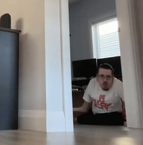 A Man Sitting On The Floor Wearing A T-Shirt That Says ' U.s.f. ' On It GIF