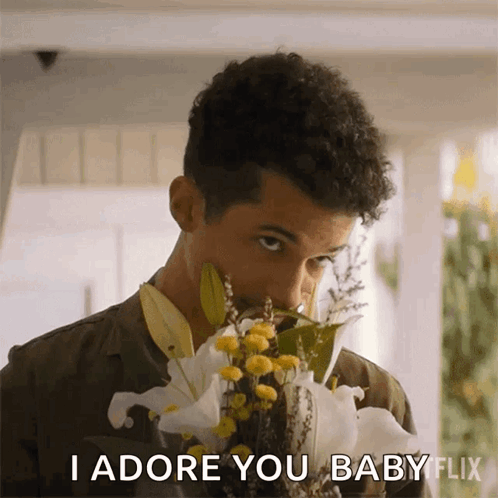 A Man Smelling A Bouquet Of Flowers With The Words I Adore You Baby Flix Below Him GIF