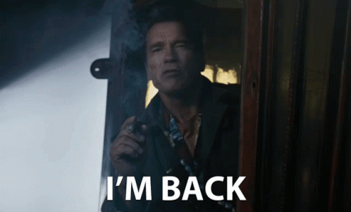 A Man Smoking A Cigarette With The Words I 'M Back Written Below Him GIF