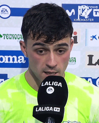 A Man Speaking Into A Laliga Tv Microphone While Wearing A Neon Green Shirt GIF
