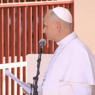 A Man Speaking Into A Microphone While Wearing A White Hat GIF