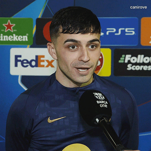 A Man Speaking Into A Microphone With A Fedex Logo In The Background GIF