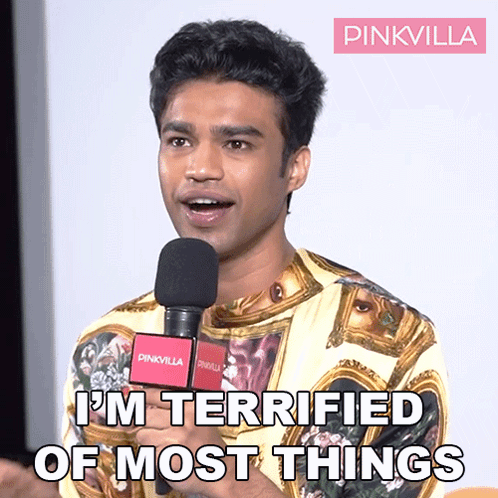 A Man Speaking Into A Microphone With The Words " I 'M Terrified Of Most Things " Above Him GIF