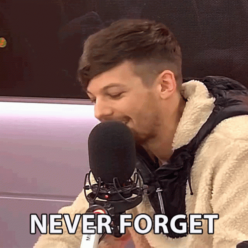 A Man Speaking Into A Microphone With The Words " Never Forget " Written Below Him GIF