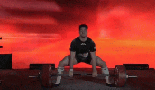 A Man Squatting Down With A Barbell In Front Of A Red Background That Says ' Powerlifting ' On It GIF
