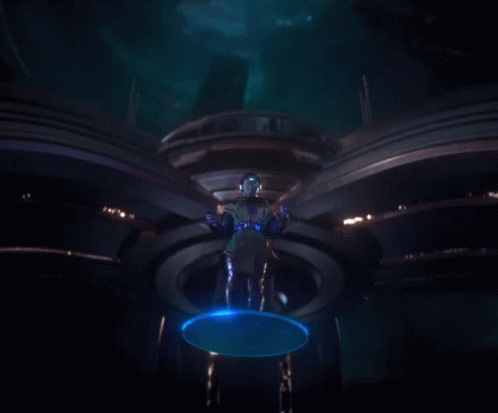 A Man Standing In A Dark Room With Blue Lights Coming Out Of His Hands GIF