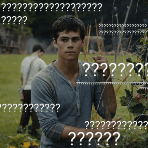 A Man Standing In A Field With A Bunch Of White Letters That Say ' ?? ' GIF