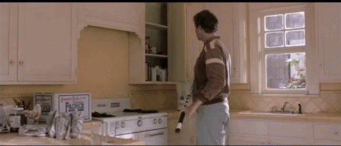 A Man Standing In A Kitchen Next To A Box That Says ' Paradise ' On It GIF