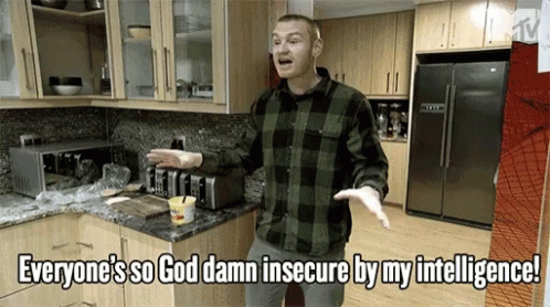 A Man Standing In A Kitchen With The Words Everyone 'S So God Damn Insecure By My Intelligence Above Him GIF