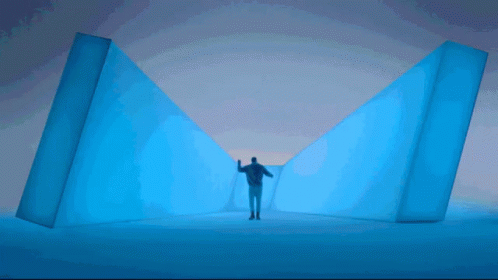 A Man Standing In A Room With A Purple Light GIF