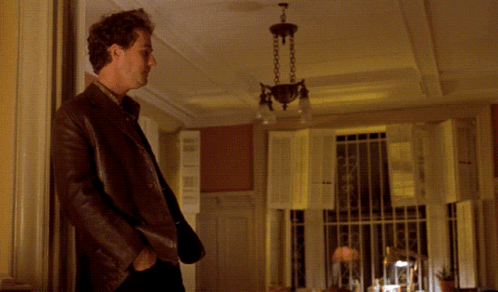A Man Standing In A Room With The Words " Don 'T Tease Me " Written Above Him GIF