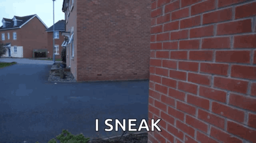 A Man Standing In Front Of A Brick Wall With The Words I Sneak Written On The Bottom GIF