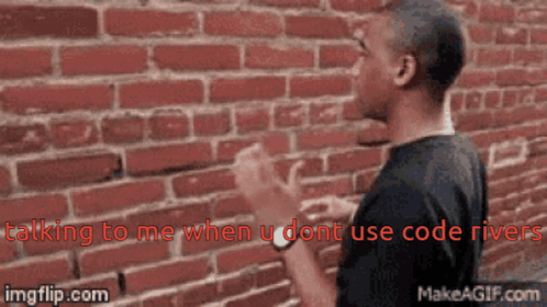 A Man Standing In Front Of A Brick Wall With The Words " Talking To Me When U Dont Use Code River " Above Him GIF