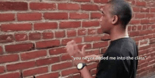 A Man Standing In Front Of A Brick Wall With The Words " You Never Added Me Into The Class " On The Bottom GIF
