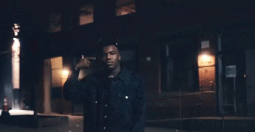 A Man Standing In Front Of A Building With A Sign That Says ' No Parking ' GIF