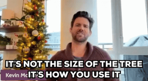 A Man Standing In Front Of A Christmas Tree With A Caption That Says It 'S Not The Size Of The Tree GIF