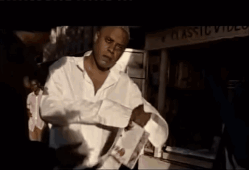 A Man Standing In Front Of A Classic Video Sign GIF