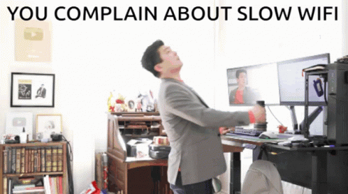 A Man Standing In Front Of A Computer With The Words You Complain About Slow Wifi GIF