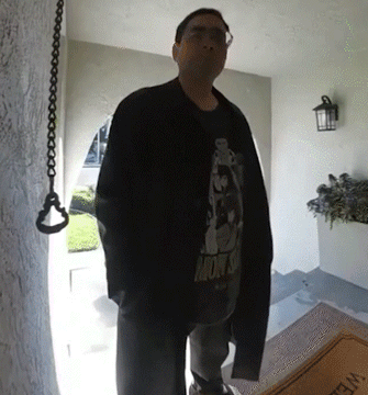 A Man Standing In Front Of A Door Wearing A Shirt That Says Monsoon GIF