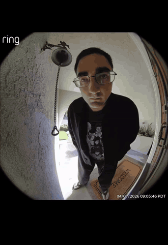A Man Standing In Front Of A Door With A Welcome Mat GIF