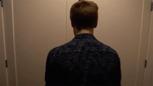 a man standing in front of a door with his back to the camera