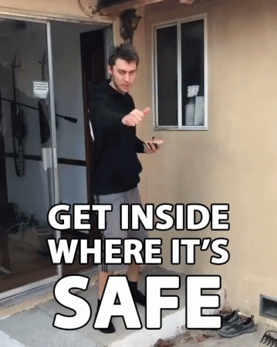 A Man Standing In Front Of A Door With The Words Get Inside Where It 'S Safe Above Him GIF