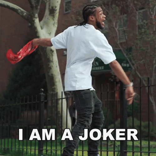 A Man Standing In Front Of A Fence With The Words " I Am A Joker " GIF