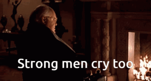A Man Standing In Front Of A Fireplace With The Words Strong Men Cry Too On The Bottom GIF