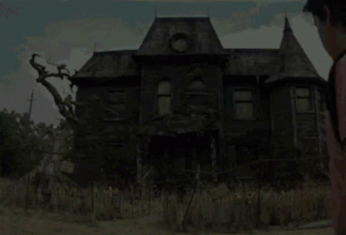 A Man Standing In Front Of A Haunted House GIF