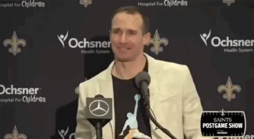 A Man Standing In Front Of A Microphone With His Arms Outstretched . GIF