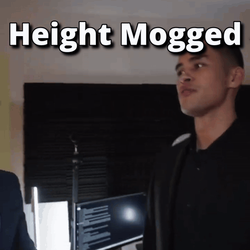 a man standing in front of a microphone with the words " height mogged " above him