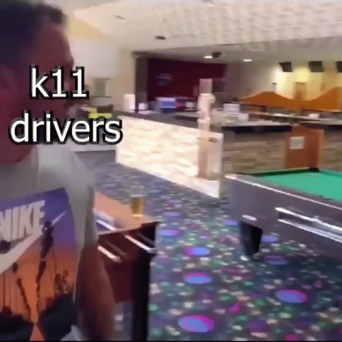 A Man Standing In Front Of A Pool Table With The Words K11 Drivers Above Him GIF