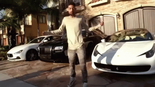 A Man Standing In Front Of A Row Of Cars GIF