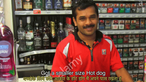 A Man Standing In Front Of A Shelf Of Liquor And Cigarettes With A Caption That Says Got A Smaller Size Hot Dog GIF