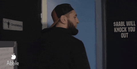 A Man Standing In Front Of A Sign That Says $ Aabll Will Knock You Out GIF