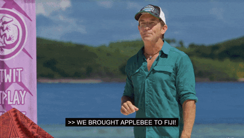 A Man Standing In Front Of A Sign That Says Twit Play GIF
