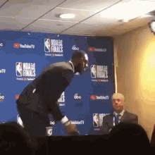 Man In Front Of NBA Finals Wall GIF