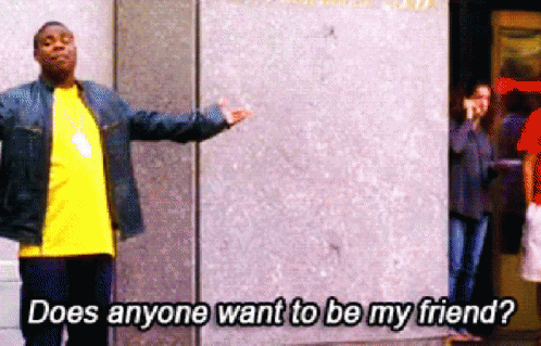A Man Standing In Front Of A Wall With The Words " Does Anyone Want To Be My Friend " GIF