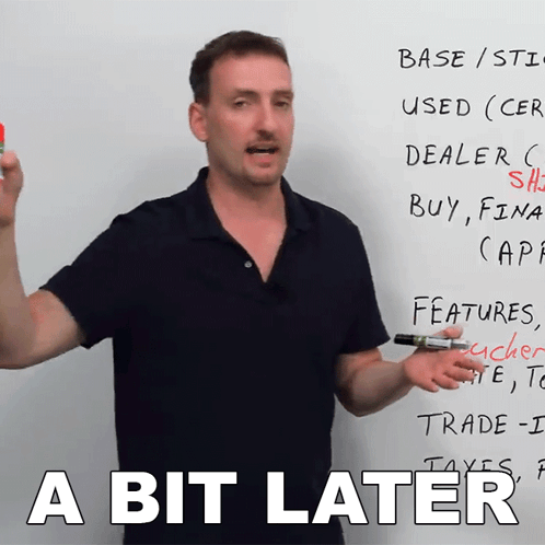A Man Standing In Front Of A White Board With The Words A Bit Later GIF