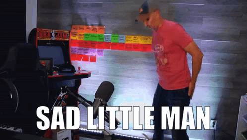 A Man Standing In Front Of An Arcade Machine That Says " Sad Little Man " On It GIF