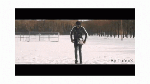 A Man Standing In The Snow With The Words By Tunurs On The Bottom Right GIF