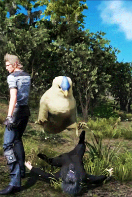 A Man Standing Next To A Bird That Is Flying Over A Person Laying On The Ground GIF