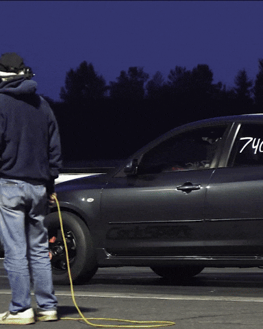 A Man Standing Next To A Car That Has The Number 740 On The Door GIF