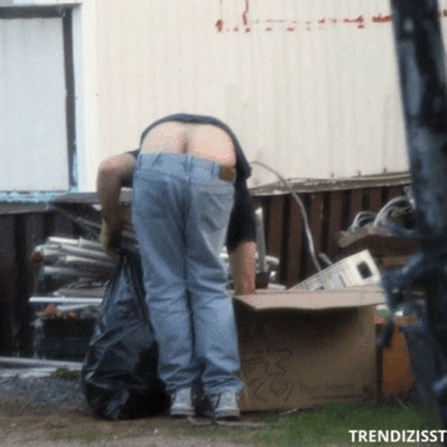 A Man Standing Next To A Cardboard Box That Says ' Recycling ' GIF