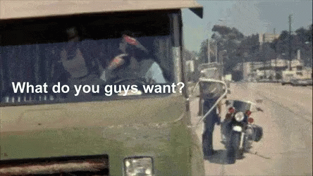 A Man Standing Next To A Motorcycle With The Words " What Do You Guys Want " On The Bottom GIF