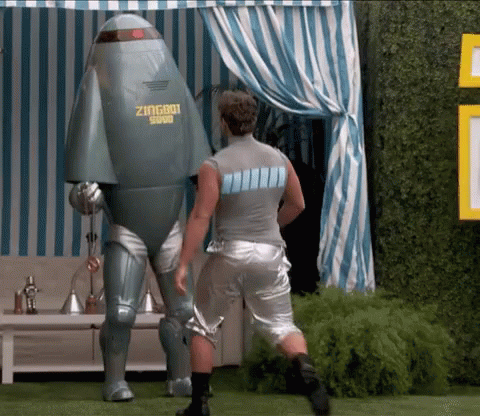 a man standing next to a robot that says zingbot